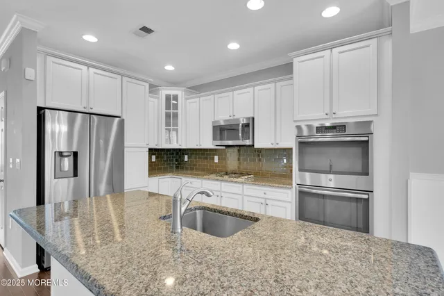 a kitchen with kitchen island a counter top space stainless steel appliances and a counter space