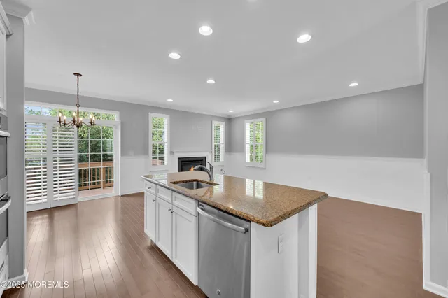 a kitchen with stainless steel appliances granite countertop a sink stove and wooden floor