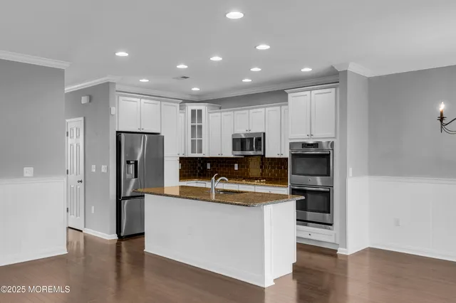 a kitchen with stainless steel appliances a refrigerator and a stove top oven
