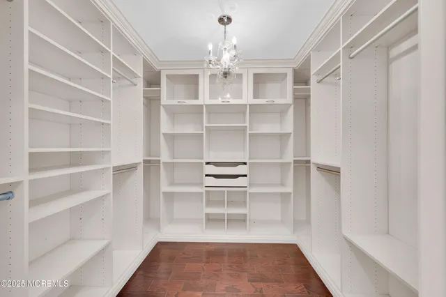 a view of a room with shelves on the wall and a chandelier