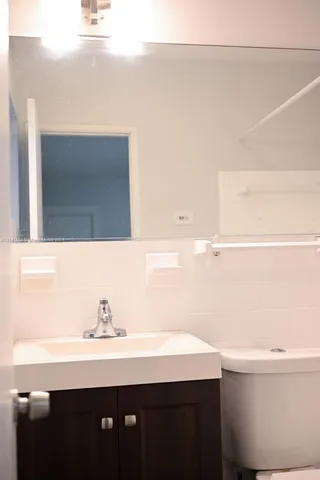 a bathroom with a sink a toilet and mirror