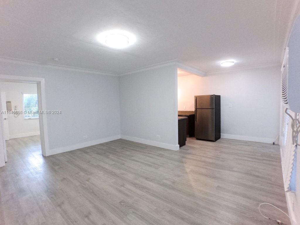 345 85th Street Miami Beach, FL 33141 - Photo 21 of 26 a view of an empty room with wooden floor and a window