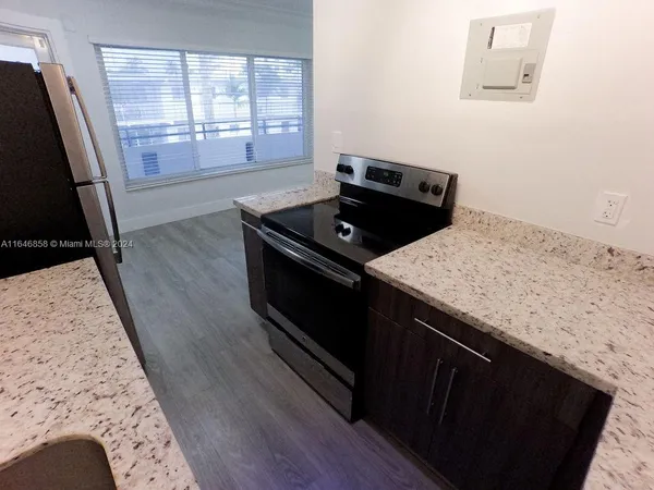 a view of a kitchen sink stove and cabinets