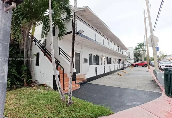 a view of a white house with a large windows and a small yard