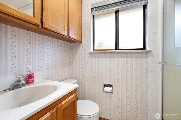 a bathroom with a sink toilet and window