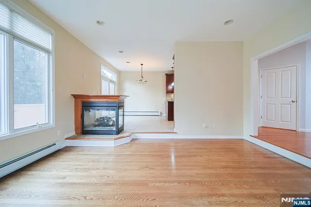 a view of empty room with wooden floor and fireplace