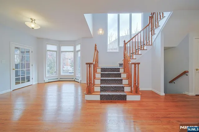 a view of staircase with wooden floor and a large window