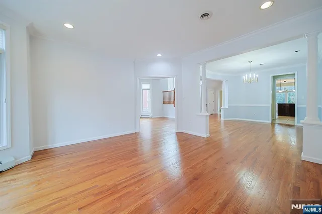 a view of a big room with wooden floor and windows