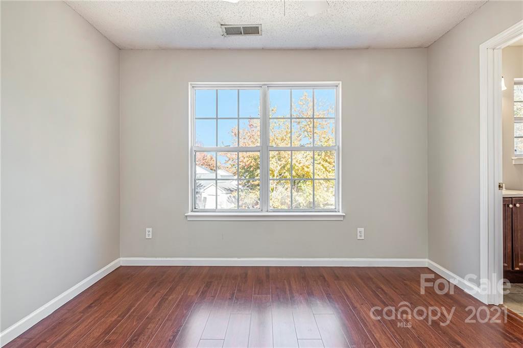 3021 Winners Circle Southwest Concord, NC 28025 - Photo 15 of 20 an empty room with wooden floor and windows