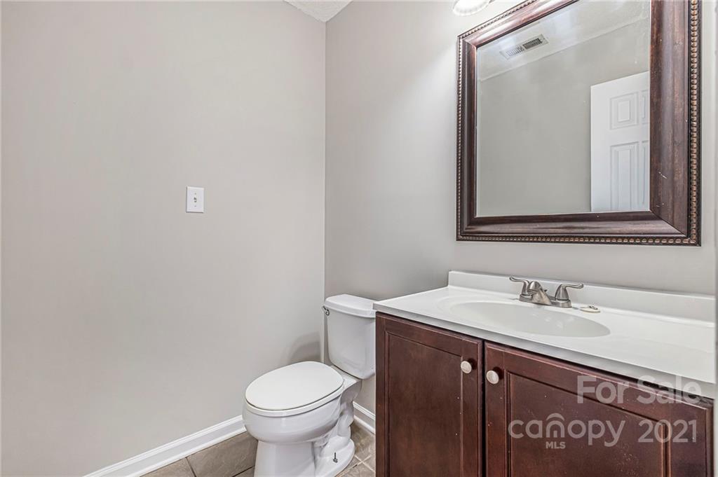 3021 Winners Circle Southwest Concord, NC 28025 - Photo 17 of 20 a bathroom with a sink a toilet and mirror