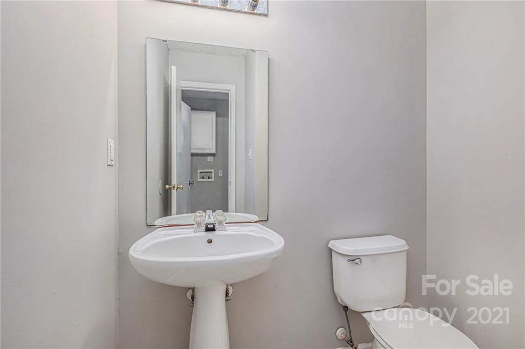 3021 Winners Circle Southwest Concord, NC 28025 - Photo 18 of 20 a bathroom with a toilet sink and mirror