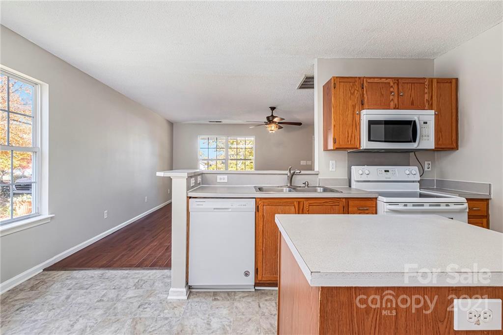 3021 Winners Circle Southwest Concord, NC 28025 - Photo 6 of 20 a kitchen with stainless steel appliances granite countertop a sink stove and microwave