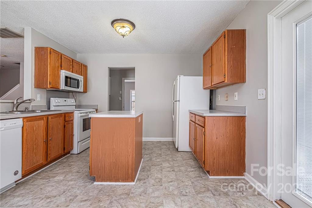 3021 Winners Circle Southwest Concord, NC 28025 - Photo 7 of 20 a kitchen with a refrigerator and a sink