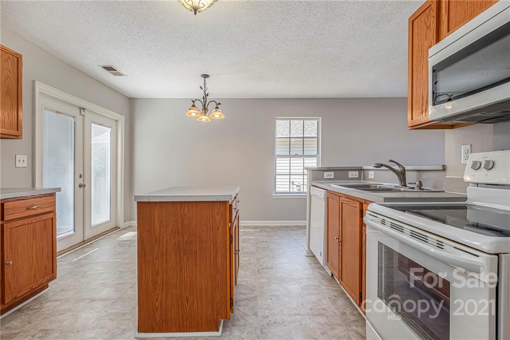 3021 Winners Circle Southwest Concord, NC 28025 - Photo 8 of 20 a kitchen with stainless steel appliances granite countertop a refrigerator and a sink