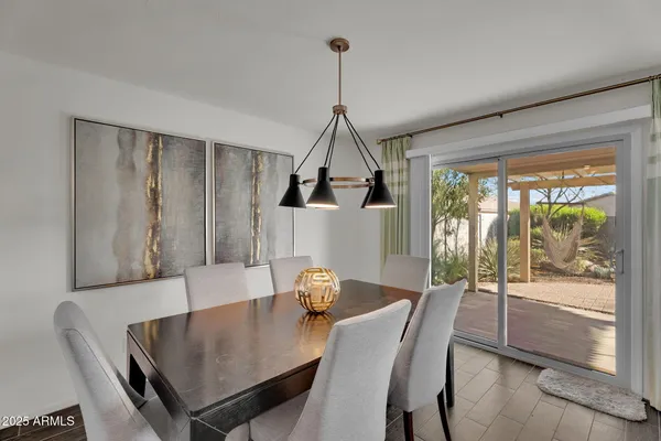 a view of a dining room and livingroom with furniture wooden floor a chandelier
