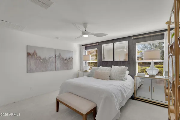 a bedroom with a bed and a painting on the wall