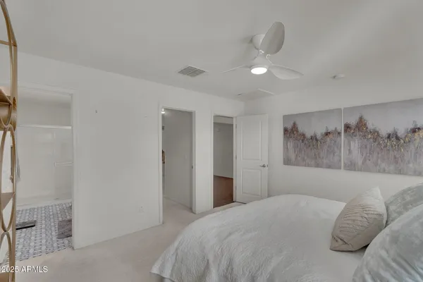a bedroom with a large bed and a chandelier