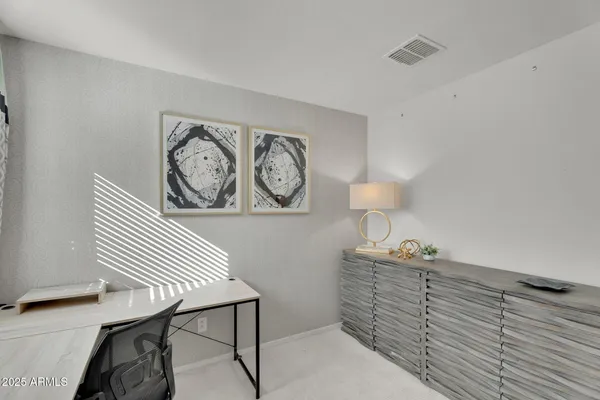 a view of a workspace with furniture and a window