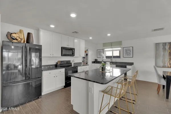 a living room with furniture a ceiling fan and a large window