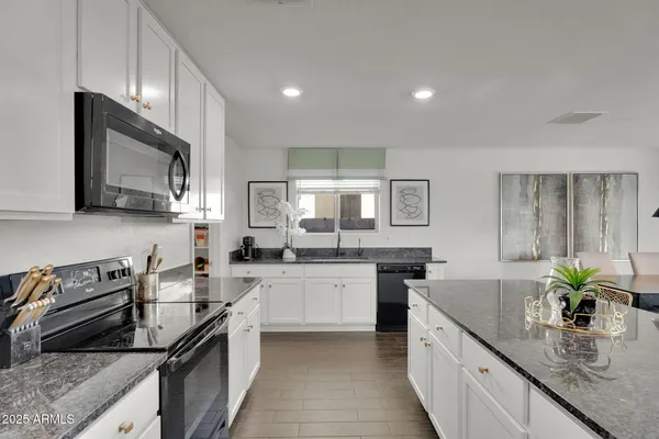 a kitchen with stainless steel appliances granite countertop a stove and a microwave