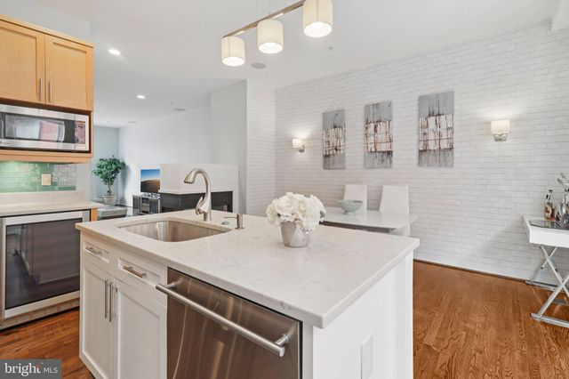 a kitchen with stainless steel appliances granite countertop a sink and a refrigerator