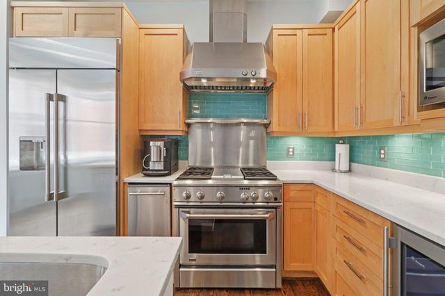 a kitchen with stainless steel appliances granite countertop a stove top oven a sink a counter space and cabinets