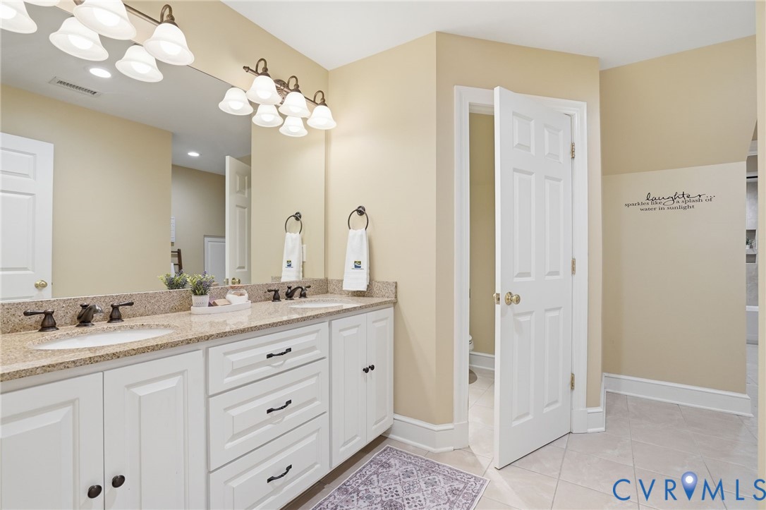12123 Deer Ridge Court Ashland, VA 23005 - Photo 45 of 63 a spacious bathroom with a granite countertop sink a mirror and a shower