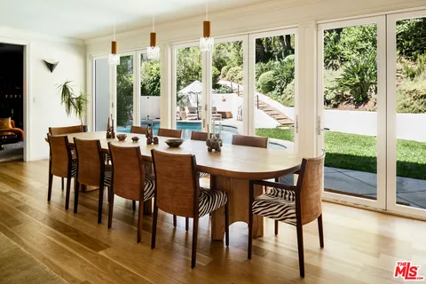 a dining room with furniture window and wooden floor