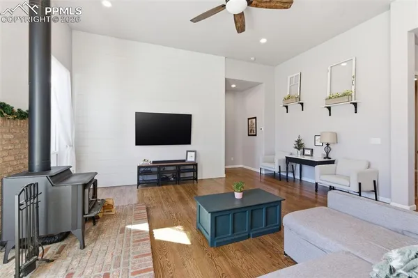 a kitchen with stainless steel appliances granite countertop a stove a refrigerator a kitchen island a sink a stove and white cabinets with wooden floor