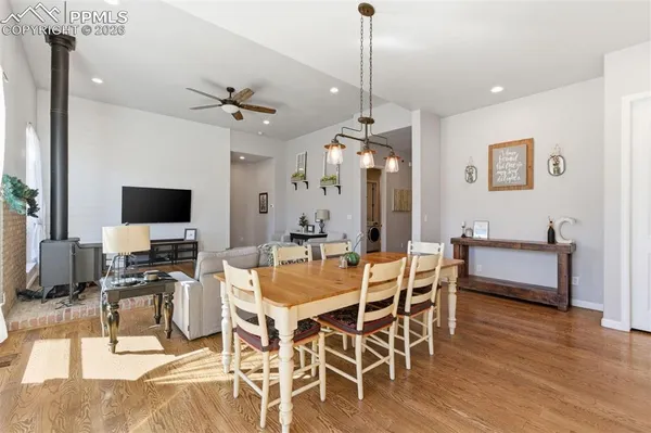 a kitchen with stainless steel appliances granite countertop a table chairs sink and cabinets