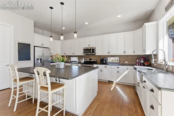 a kitchen with stainless steel appliances kitchen island granite countertop a sink and cabinets