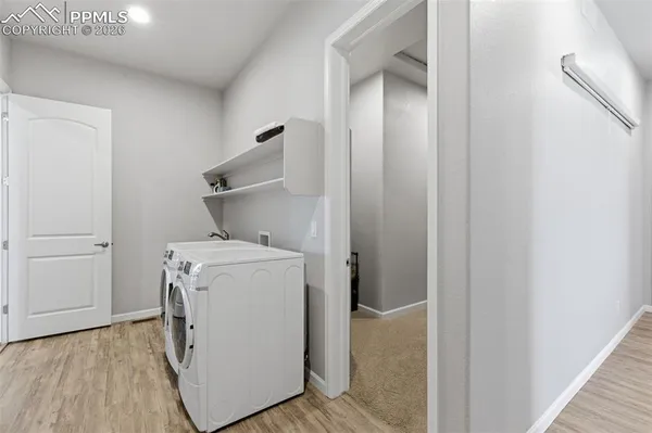a view of an empty room with wooden floor and closet