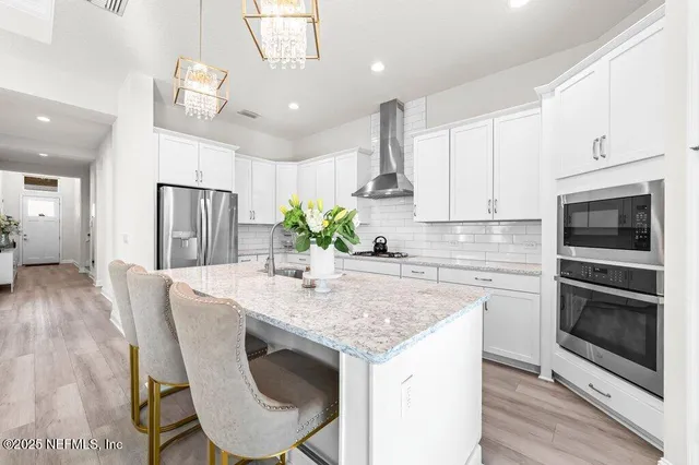 a kitchen with kitchen island a counter space a sink appliances and cabinets