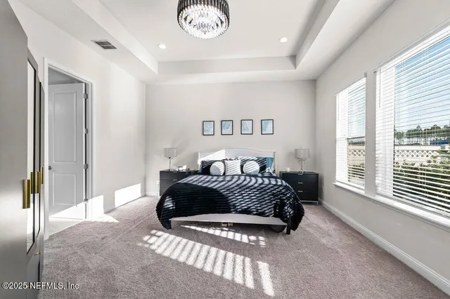 a spacious bedroom with a bed and a large window