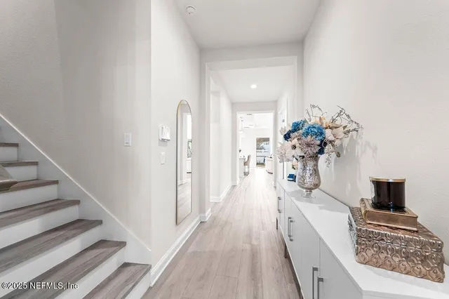 a hallway with a flower pot and a flat screen tv