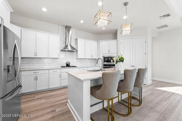 a kitchen with stainless steel appliances granite countertop a white cabinets and wooden floor