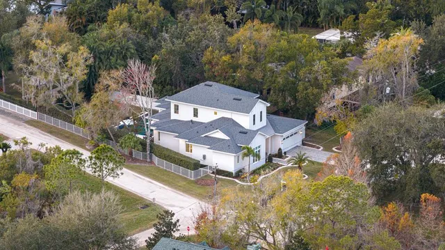 an aerial view of a house with a yard swimming pool and outdoor seating