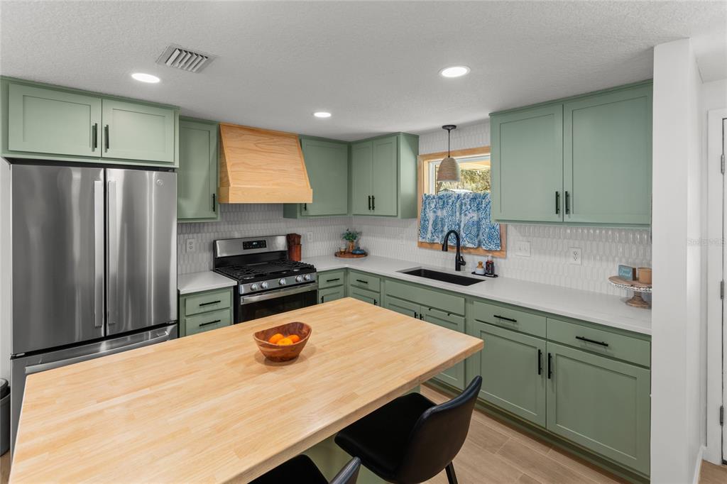 5921 County Road 352 Keystone Heights, FL 32656 - Photo 30 of 73 a kitchen with stainless steel appliances a stove a sink a refrigerator and cabinets