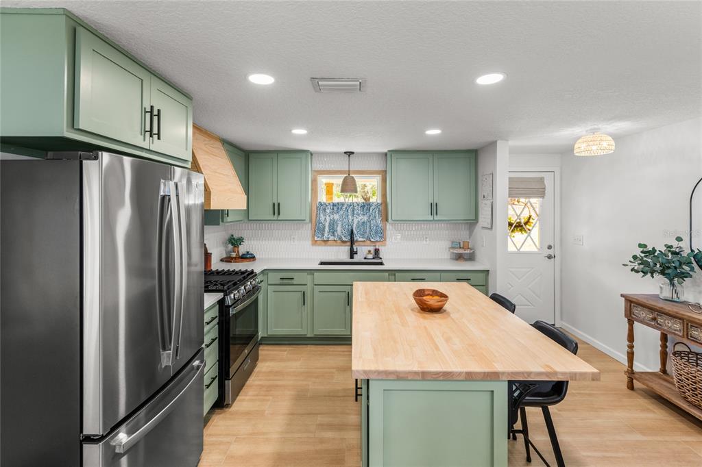 5921 County Road 352 Keystone Heights, FL 32656 - Photo 31 of 73 a kitchen with stainless steel appliances granite countertop a refrigerator a sink dishwasher a stove and white cabinets with wooden floor