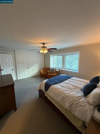 a bedroom with a large bed and a window