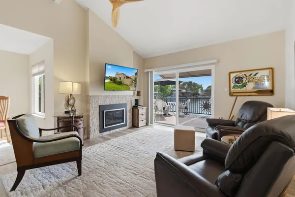 a living room with furniture a flat screen tv and a fireplace