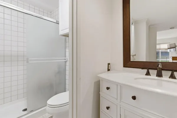 a bathroom with a sink a toilet and shower