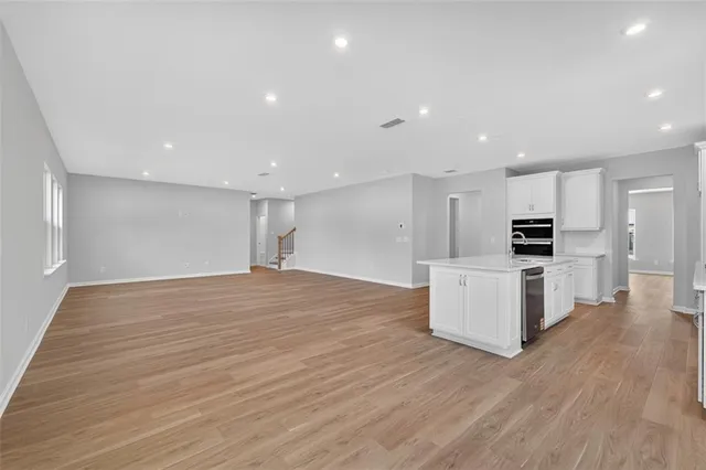 a view of kitchen with kitchen island stainless steel appliances refrigerator stove microwave and cabinets