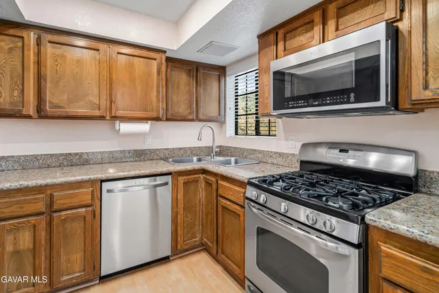 a kitchen with stainless steel appliances granite countertop a stove microwave and sink