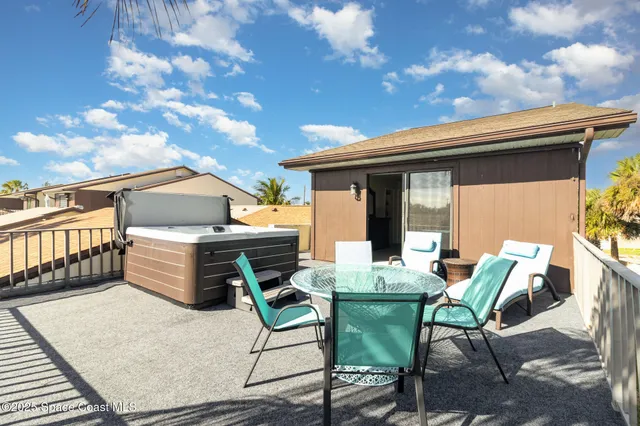 a view of a patio with table and chairs with wooden floor and fence