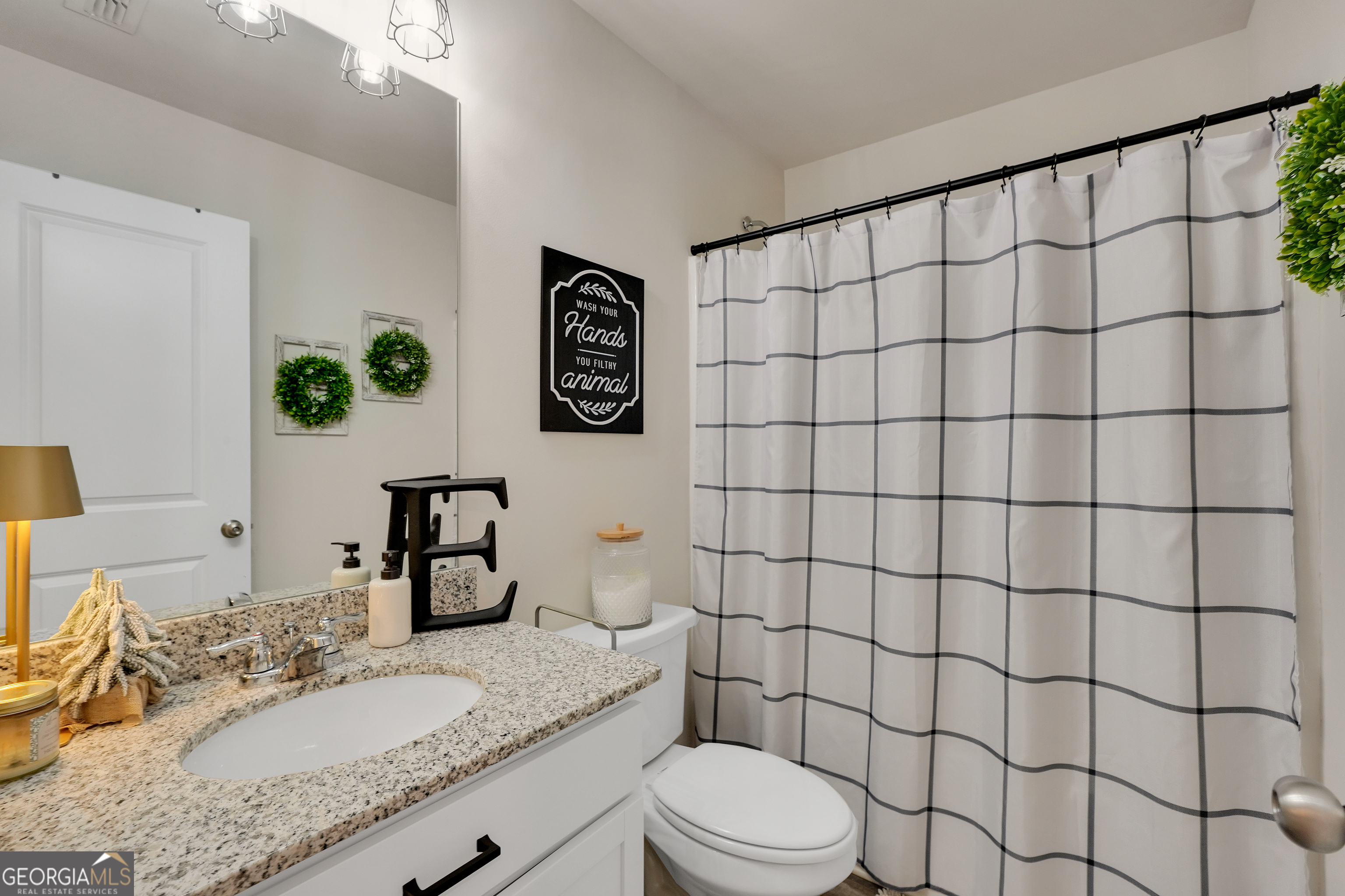 135 Catalpa Road Milner, GA 30257 - Photo 24 of 29 a bathroom with a granite countertop sink a toilet and shower
