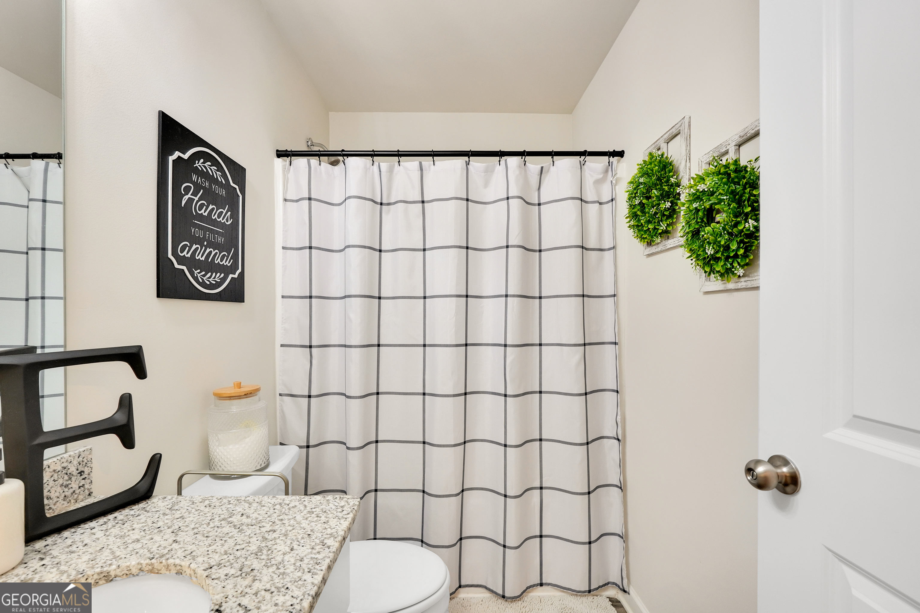 135 Catalpa Road Milner, GA 30257 - Photo 25 of 29 a bathroom with a toilet sink and shower curtain