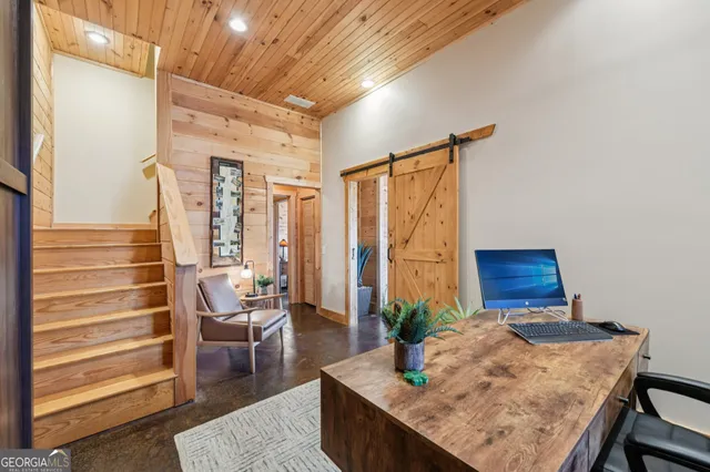 a bedroom with a bed and large windows