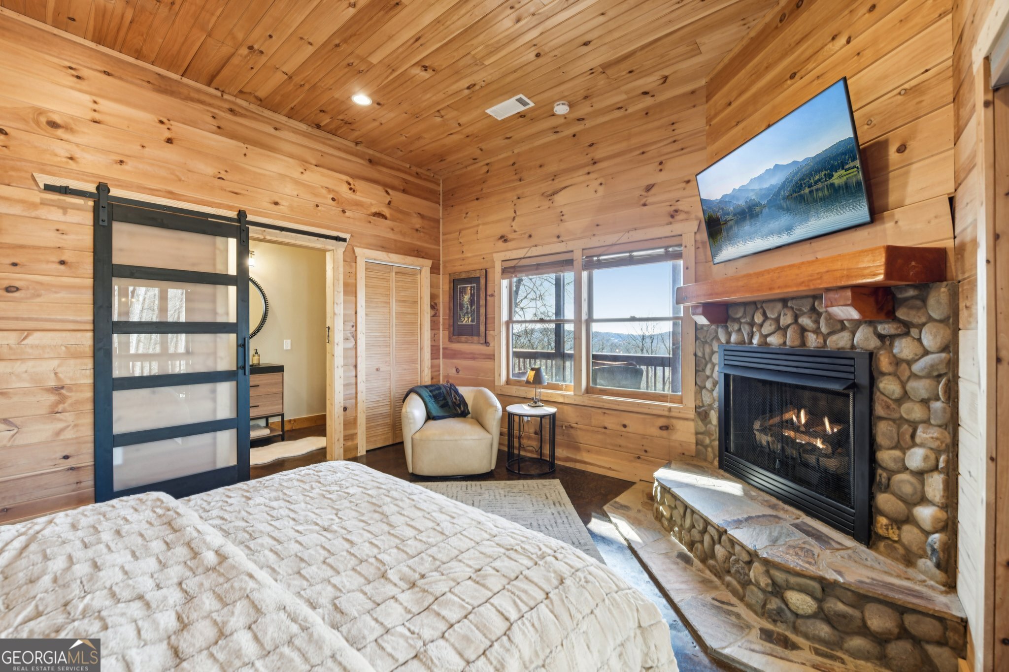 232 Ranch Mountain Drive Dahlonega, GA 30533 - Photo 39 of 78 a bedroom with a bed a fireplace and a large window