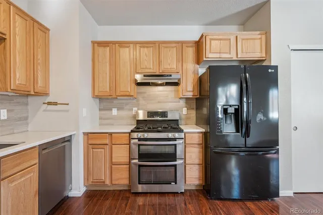 a kitchen with a stove refrigerator and microwave